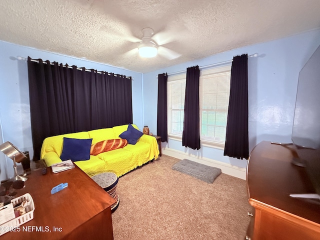 carpeted bedroom with ceiling fan and a textured ceiling