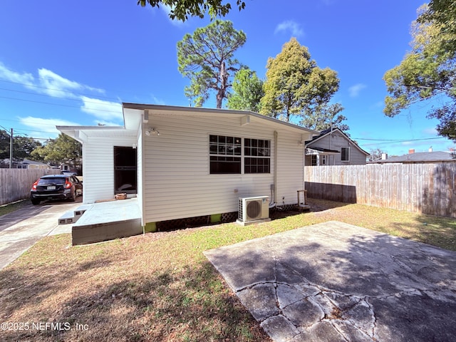 rear view of property with ac unit and a patio