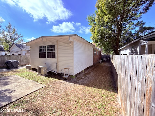 view of side of property with ac unit and a patio area