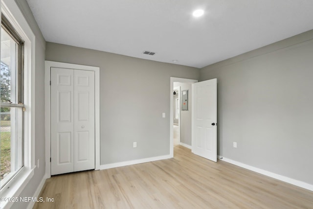 unfurnished bedroom with a closet and light wood-type flooring