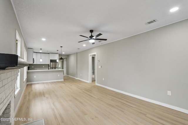 unfurnished living room featuring ceiling fan and light hardwood / wood-style floors