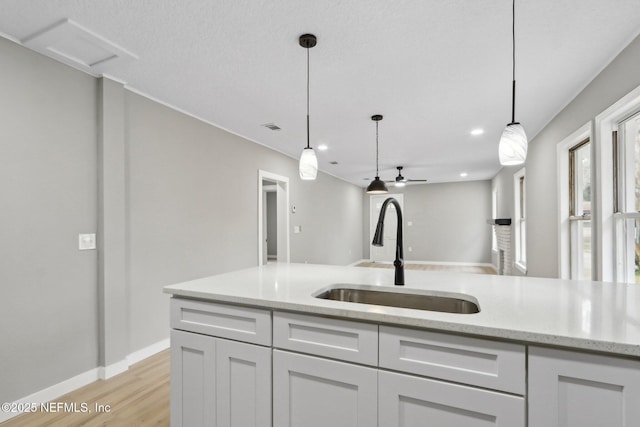 kitchen with light stone countertops, sink, and white cabinets