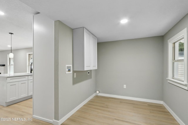 laundry area with cabinets, hookup for a washing machine, light hardwood / wood-style floors, and hookup for an electric dryer