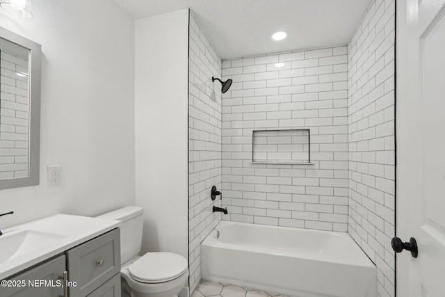 full bathroom featuring vanity, tile patterned floors, toilet, and tiled shower / bath