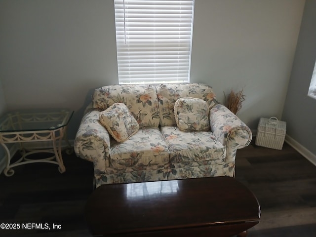 living area with baseboards and wood finished floors