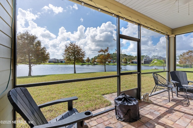 sunroom / solarium featuring a water view