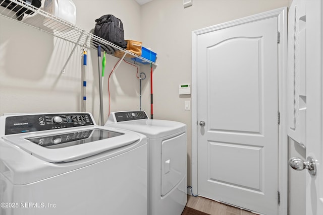 laundry room with hardwood / wood-style flooring and washing machine and clothes dryer