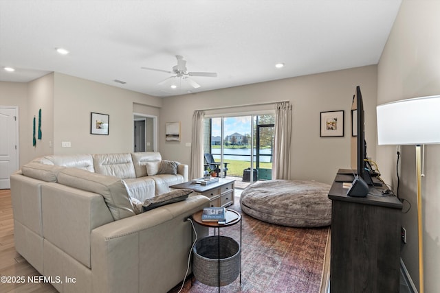 living room featuring wood-type flooring and ceiling fan