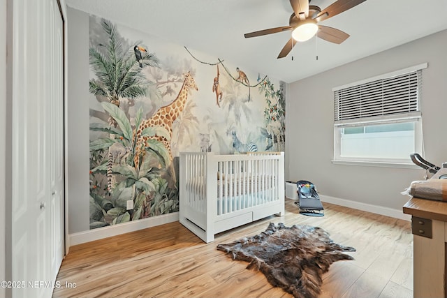 bedroom featuring ceiling fan, baseboards, and wood finished floors