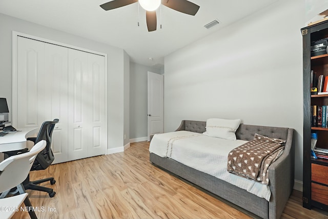 bedroom featuring visible vents, wood finished floors, a closet, baseboards, and ceiling fan