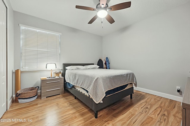 bedroom with baseboards, light wood-type flooring, and ceiling fan