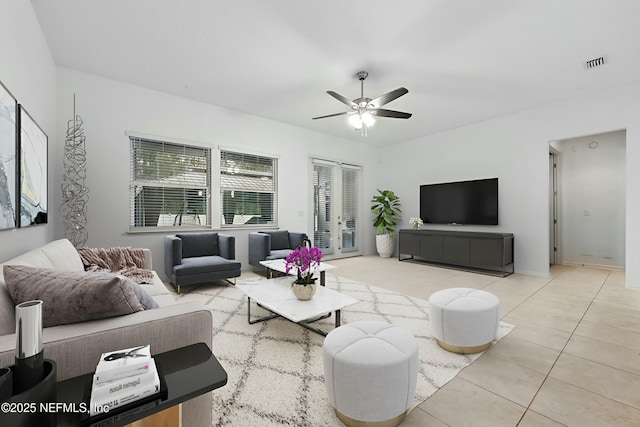 living room with tile patterned floors, visible vents, and a ceiling fan