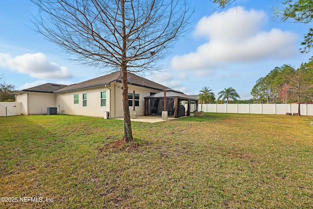 view of yard featuring a gazebo, a fenced backyard, central AC, and a patio