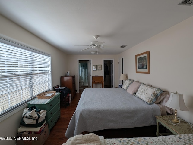 bedroom featuring dark hardwood / wood-style flooring, ensuite bath, and ceiling fan