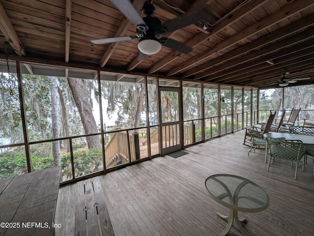 unfurnished sunroom with wood ceiling, ceiling fan, and plenty of natural light