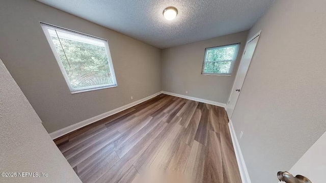 spare room with hardwood / wood-style floors and a textured ceiling