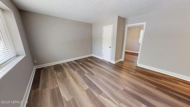 unfurnished room featuring hardwood / wood-style floors and a textured ceiling