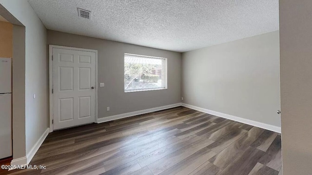 unfurnished room with dark hardwood / wood-style floors and a textured ceiling