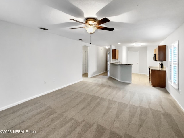 unfurnished living room featuring light colored carpet and ceiling fan