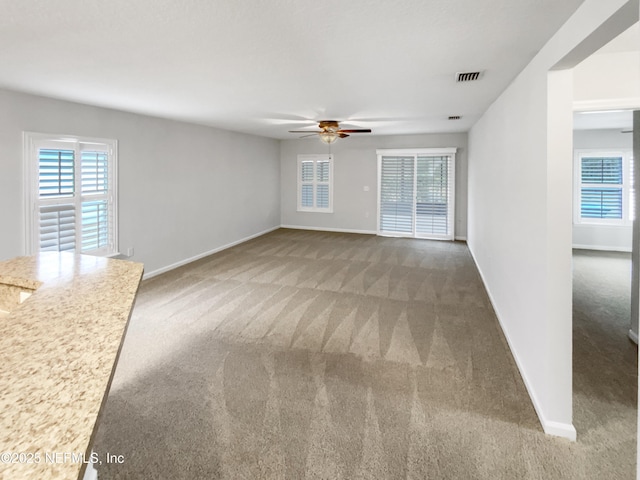 unfurnished living room featuring ceiling fan and carpet floors