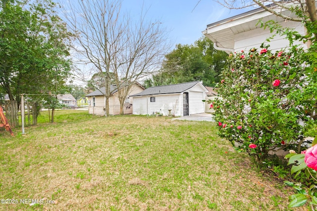 view of yard featuring a garage and an outdoor structure