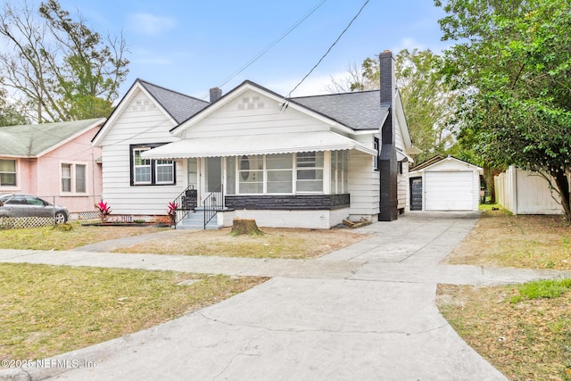 bungalow-style house with a garage, an outdoor structure, and a front yard