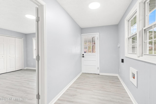 doorway with light hardwood / wood-style flooring and a textured ceiling