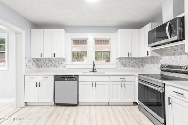 kitchen featuring white cabinetry, appliances with stainless steel finishes, sink, and plenty of natural light