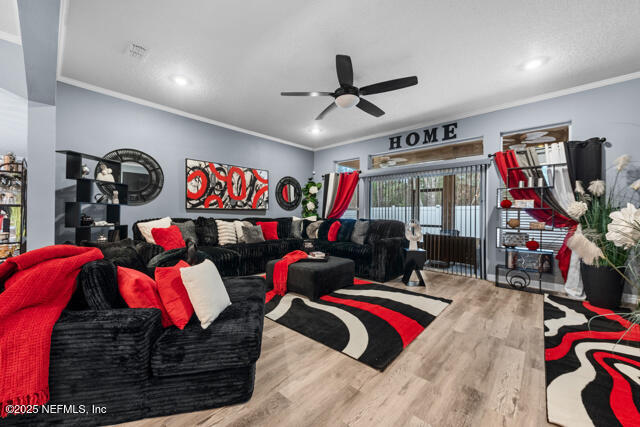 living room with crown molding, hardwood / wood-style floors, and ceiling fan