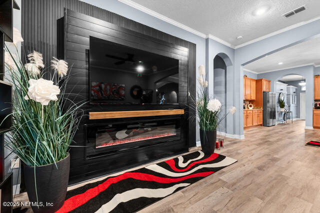 room details featuring crown molding, refrigerator, hardwood / wood-style floors, and a textured ceiling