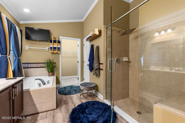 bathroom with vanity, hardwood / wood-style flooring, ornamental molding, and independent shower and bath