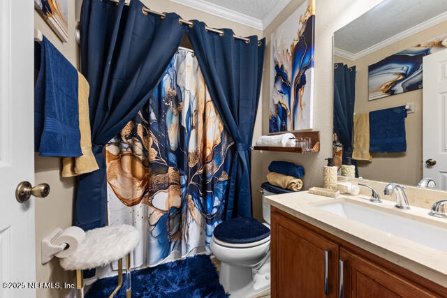 bathroom with vanity, ornamental molding, and toilet