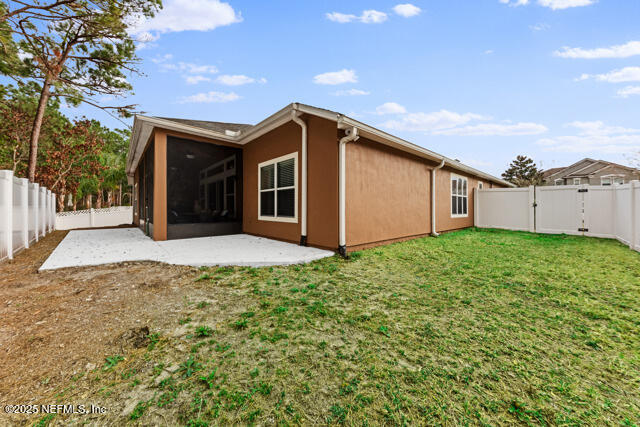 back of property with a yard and a patio area