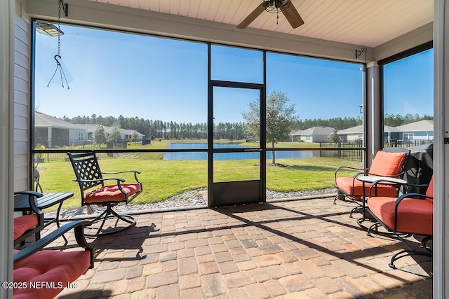 sunroom with a water view, ceiling fan, and plenty of natural light