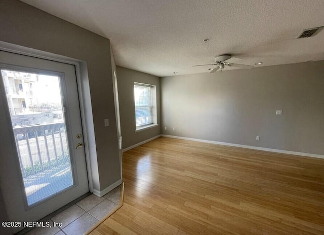 interior space with ceiling fan, light hardwood / wood-style floors, and a textured ceiling