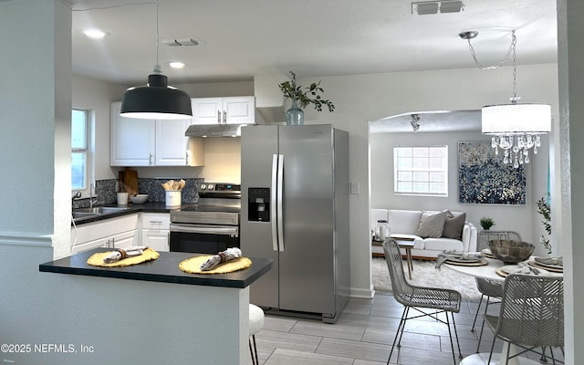 kitchen with white cabinetry, appliances with stainless steel finishes, sink, and kitchen peninsula