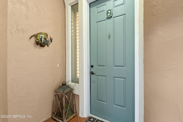 property entrance with stucco siding