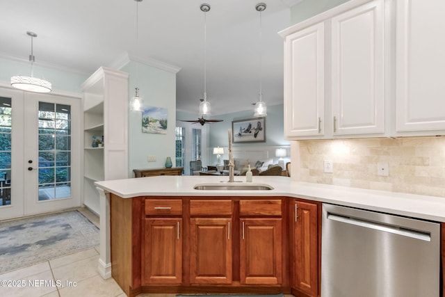 kitchen with ornamental molding, a sink, a peninsula, light tile patterned floors, and dishwasher