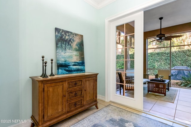 doorway to outside featuring light tile patterned floors, ceiling fan, and ornamental molding