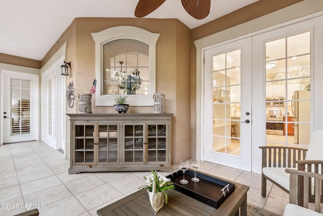 interior space with tile patterned floors, french doors, and a ceiling fan