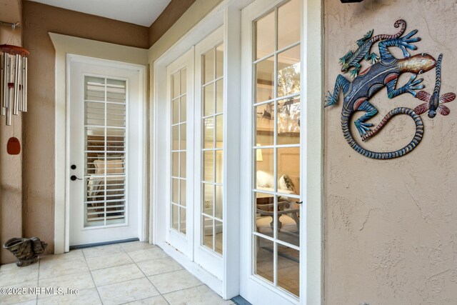 doorway to outside featuring tile patterned floors and a textured wall