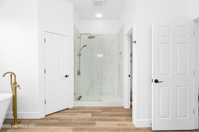 bathroom with wood-type flooring, plus walk in shower, and toilet