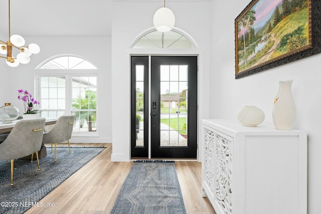 entryway featuring an inviting chandelier and light hardwood / wood-style flooring