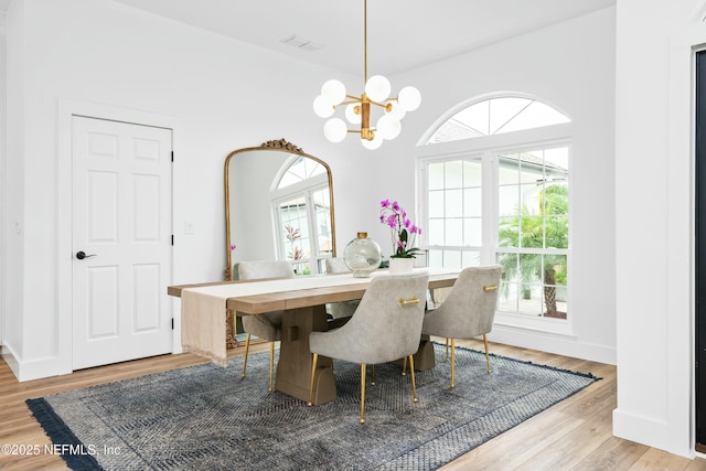 dining area featuring hardwood / wood-style flooring and an inviting chandelier