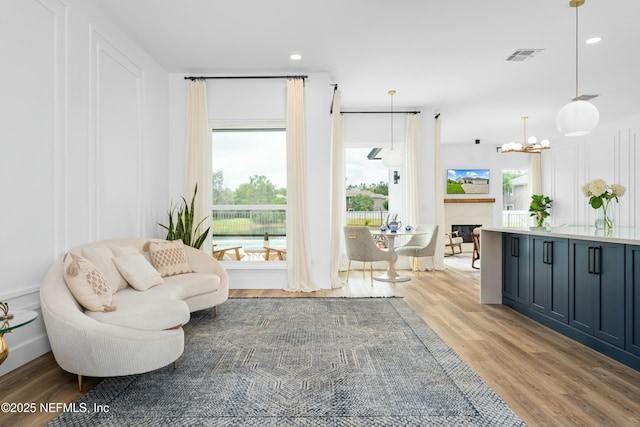 living area featuring a notable chandelier and light wood-type flooring