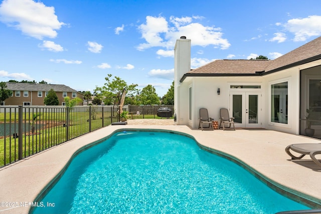 view of pool with french doors and a patio