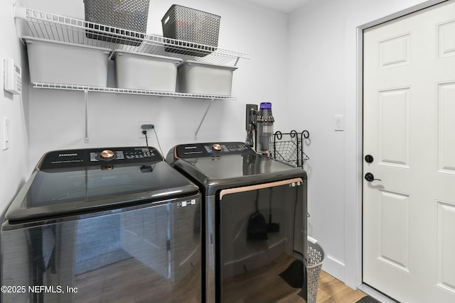 washroom featuring hardwood / wood-style floors and washing machine and clothes dryer