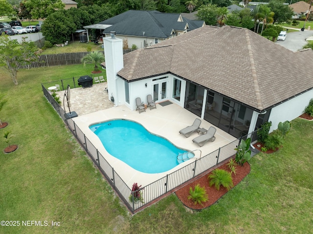 view of pool featuring a patio, a yard, grilling area, a sunroom, and french doors