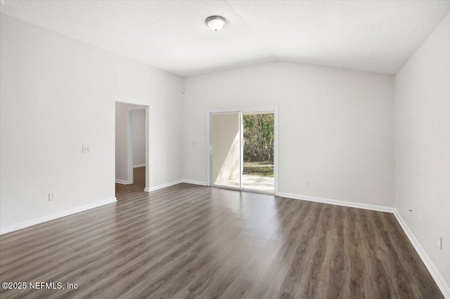 spare room with dark wood-type flooring, vaulted ceiling, and a textured ceiling