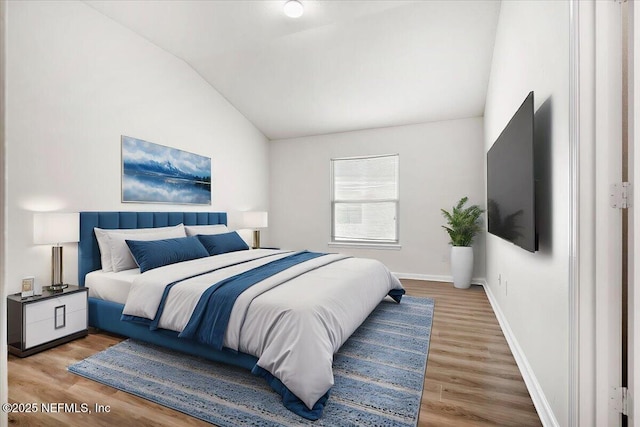 bedroom with vaulted ceiling and hardwood / wood-style floors